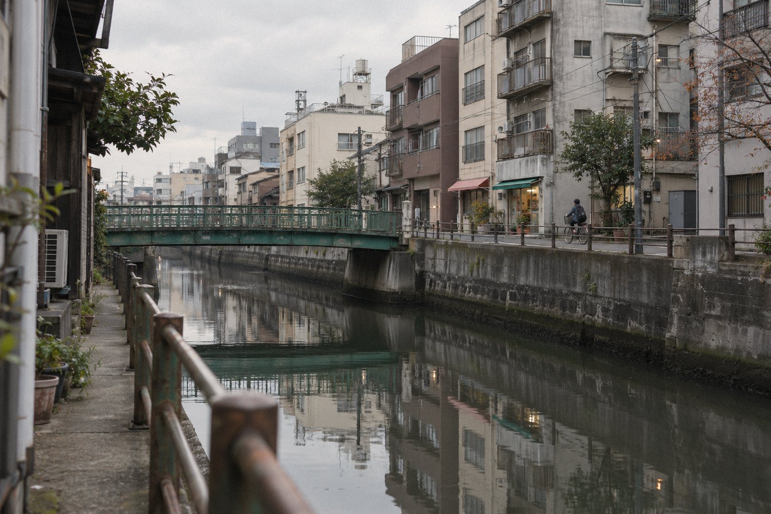 朝の大横川。古い緑の橋と、川沿いの建物